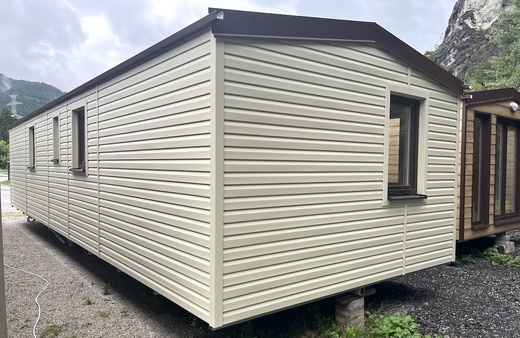 Mobilní dům bílý s hnědými okny a střechou – moderní vzhled