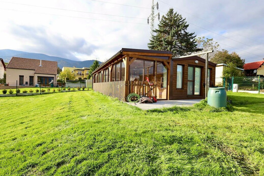 Mobilní dům s dřevěnou fasádou a prosklenou terasou